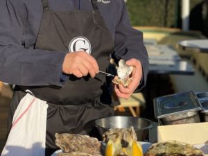 Photo of a shucker opening an oyster